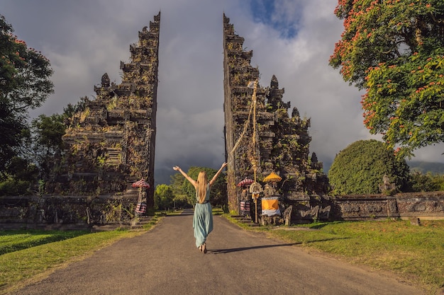 Turystyczna kobieta przechodząca przez tradycyjną balijską bramę hinduską Candi Bentar w pobliżu jeziora Bedugul Bratan Wyspa Bali Indonezja Wakacje na Bali