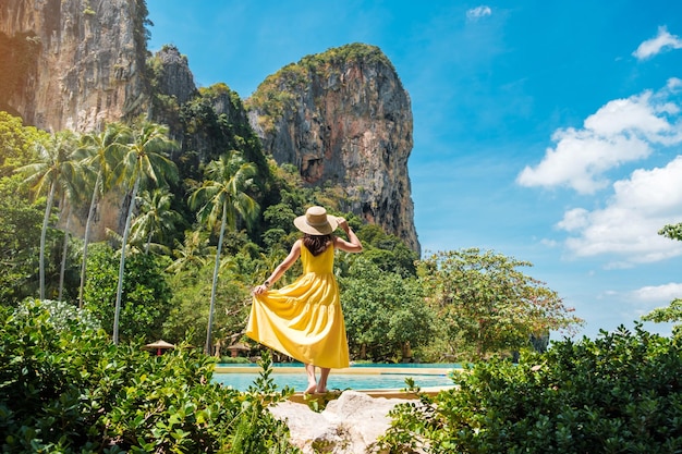 Turystyczna Kobieta W żółtej Sukience I Kapeluszu Podróżująca Po Plaży Railay Krabi Tajlandia Wakacje Podróż Lato Wanderlust I Koncepcja Wakacji