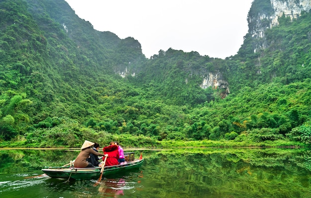 Turystyczna łódź wiosłowa w kompleksie krajobrazowym Trang An w prowincji Ninh Binh w Wietnamie