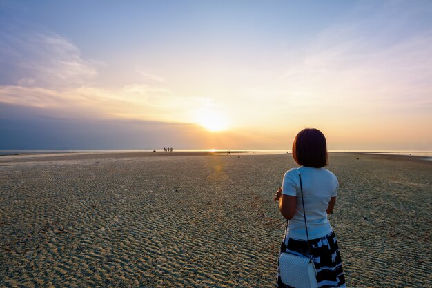 Turystyczne kobiety stojące na plaży oglądając piękny naturalny krajobraz, kolorowe niebo i morze podczas zachodu słońca w punkcie widokowym Nathon Sunset na wyspie Ko Samui, Surat Thani, Tajlandia