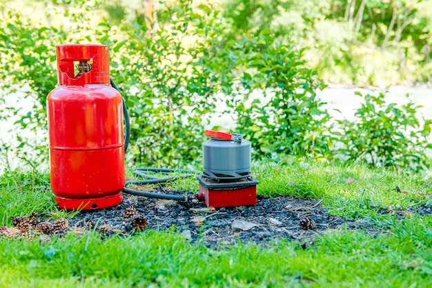 Zdjęcie turystyczny czajnik gazowy w naturze czajnik gotujący się na kuchence kempingowej do parzenia herbaty podczas biwakowania