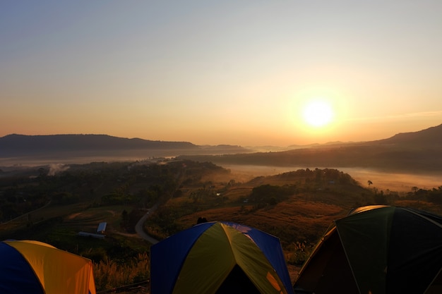 Zdjęcie turystyczny namiot na zielonej trawy polu przy wschodem słońca