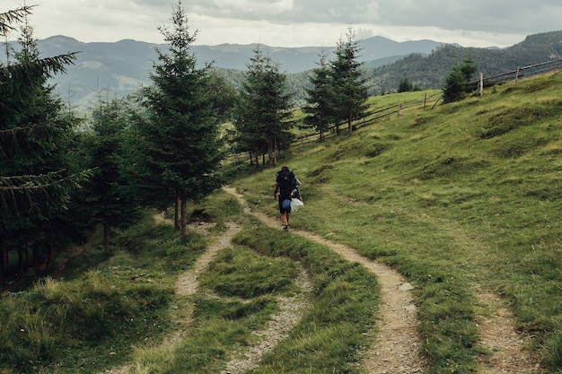 Turystyka, góry, styl życia, natura, koncepcja ludzi - grupa turystów z plecakami idzie szlakiem w kierunku grzbietu górskiego. Styl Backpackers. Koncepcja aktywnego wypoczynku...