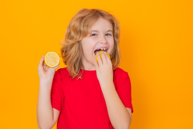 Twarz dzieci z owocami Dziecko je cytrynę w studio Portret studyjny cute boy kid lizać cytrynę samodzielnie na żółto