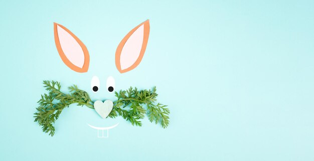 Twarz króliczka wielkanocnego, nos w kształcie serca, wąsy z liści marchwi, świąteczna kartka z życzeniami, wiosna