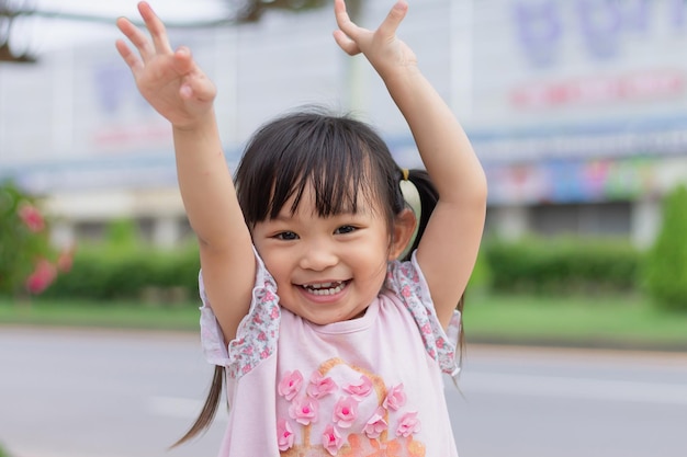 Twarz uśmiechnięta i śmiejąca się Azjatycka dziewczyna Szczęśliwe dziecko bawiące się na parkowym placu zabaw