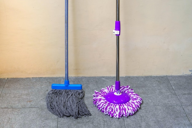 Zdjęcie two simple modern floor mops leaned against the wall