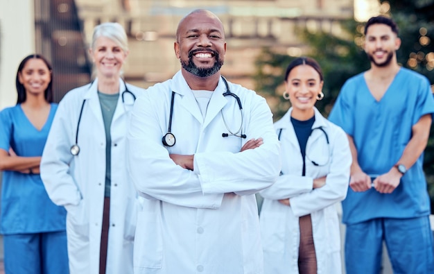 Twoje zdrowie jest dla nas priorytetem Ujęcie grupy lekarzy stojących w mieście ze skrzyżowanymi rękami