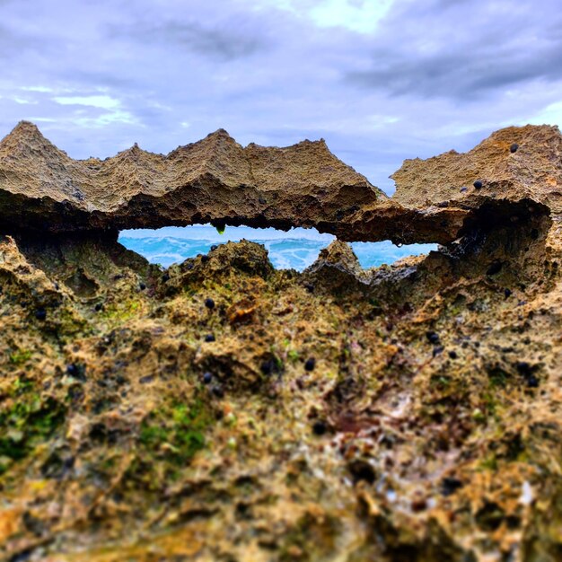 Zdjęcie tworzenie się skał na lądzie przeciwko niebu i falom oceanu