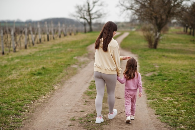 Tył chodzącej matki z córką