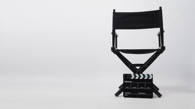 Zdjęcie tył czarnego krzesła reżysera i deski klapy. jest używany w produkcji wideo lub przemyśle filmowym i kinowym na białym tle