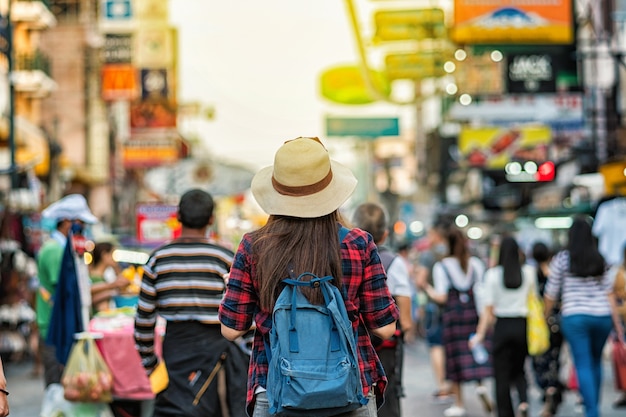 Tylna strona Młode Azjatyckie podróżne kobiety chodzi i patrzeje w Khaosan Drogowej chodzącej ulicie w eveni