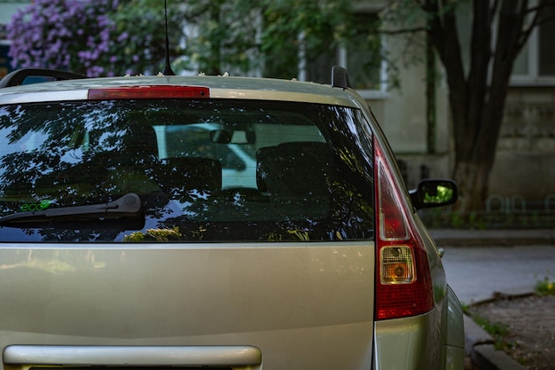 Tylne okno szary samochód zaparkowany na ulicy w słoneczny letni dzień, widok z tyłu. Makieta do naklejki lub kalkomanii