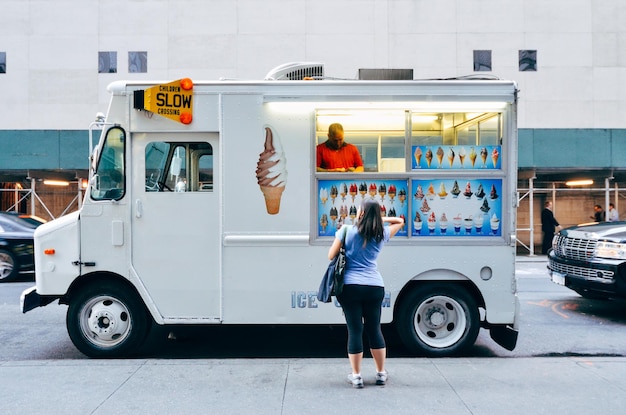 Zdjęcie tylny widok kobiety kupującej od sprzedawcy food trucków