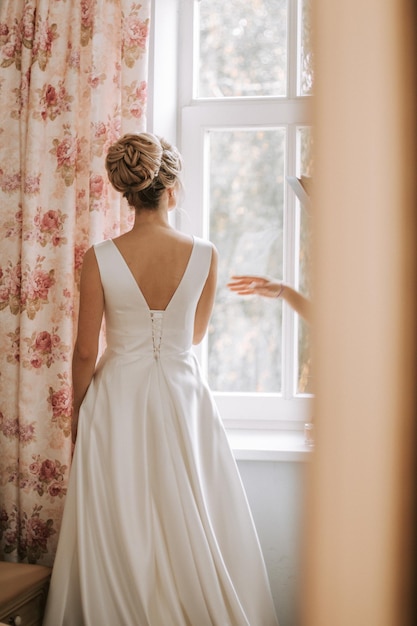 Tylny widok kobiety stojącej przy oknie