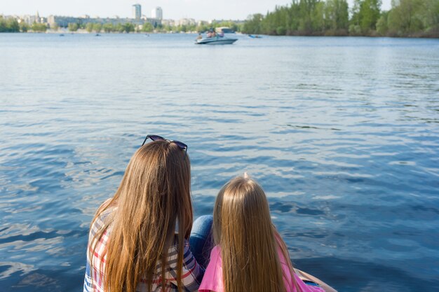 Tylny widok matka i córka ogląda wodę