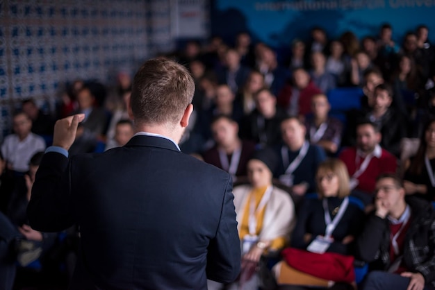 tylny widok młodego biznesmena w sali konferencyjnej z publicznymi prezentacjami. Publiczność w sali konferencyjnej. Klub przedsiębiorczości