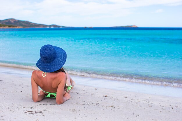 Tylny widok relaksuje przy tropikalną plażą podczas wakacje kobieta