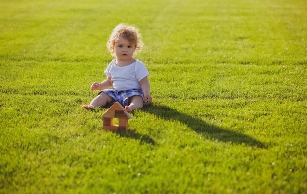 Ubezpieczenie dzieci dziecko bawi się w zielonej trawie ciepły wiosenny czas w parku