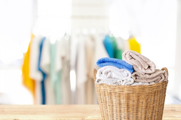 Zdjęcie ubrania w wiklinowym koszu na drewnianym stole w pralnikoncepcja prac domowych