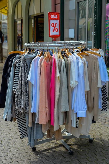 ubrania wiszące na ulicy ze zniżkami w pobliżu sklepu, cyber poniedziałek i czarny piątek