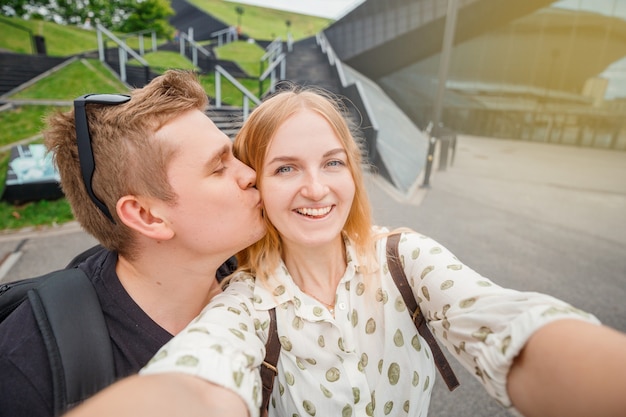 Uchwyć jasne chwile. Radosna młoda kochająca para co selfie w aparacie. Ładni turyści robią śmieszne zdjęcia na blog podróżniczy