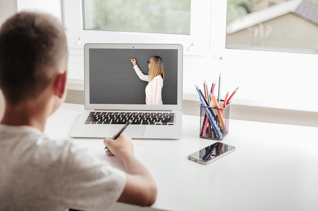 Ucz się w domu poprzez nauczanie domowe online. dziecko siedzi przy komputerze