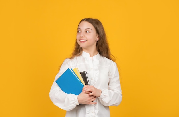 Ucz się ze skoroszytem inteligentne uśmiechnięte dziecko trzymaj książkę z powrotem do szkolnej edukacji dziecięcej