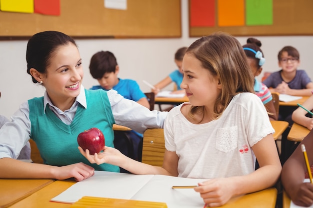 Uczeń oferuje jabłko nauczycielowi