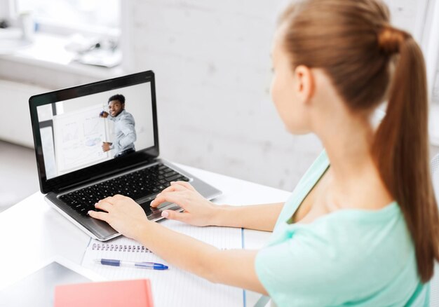 Uczeń oglądający webinar na laptopie w biurze domowym