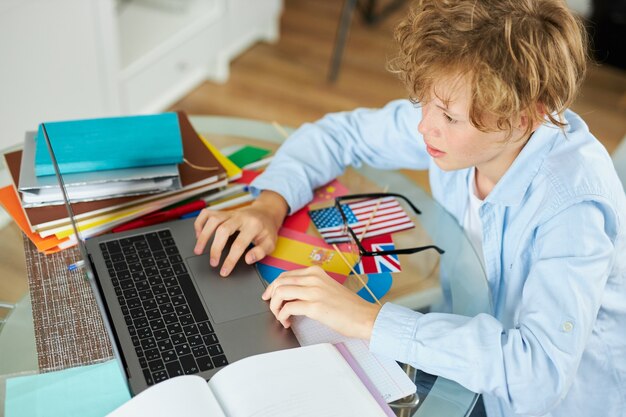 Zdjęcie uczeń pisze raport na laptopie, odrabia lekcje