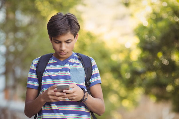 Uczeń przy użyciu telefonu komórkowego w kampusie