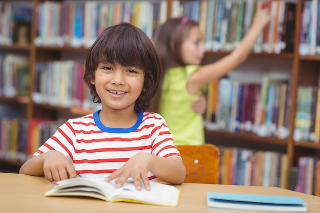 Uczeń uśmiecha się do kamery w bibliotece