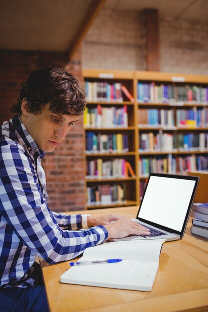 Uczeń używa laptop w bibliotece