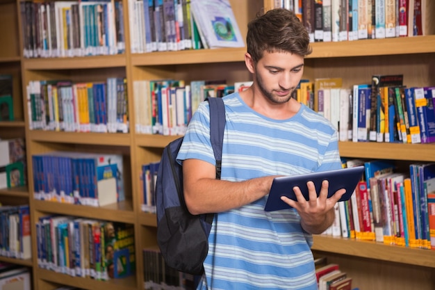 Uczeń za pomocą tabletu w bibliotece