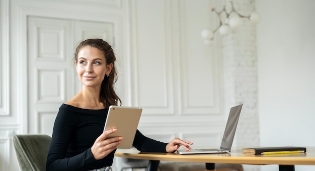 Uczennica freelancer pracująca w biurze przy użyciu miejsca coworkingowego do wynajęcia na laptopie