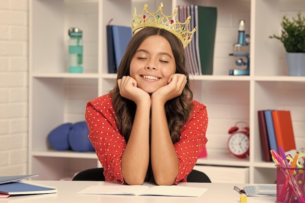 Uczennica księżniczki Portret śniącej nastoletniej dziewczyny z uczuciem korony Księżniczka Dziecko korona księżniczki na odosobnionym tle studyjnym