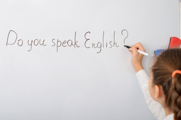 Zdjęcie uczennica pisze napis czy mówisz po angielsku