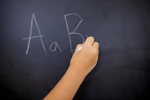 Uczennica ręka pisze litery alfabetu