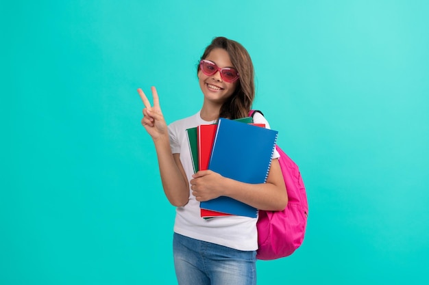 Uczennica z dzieciństwa ze szkolną torbą w liceum szczęśliwa dziewczyna nosi plecak i zeszyt