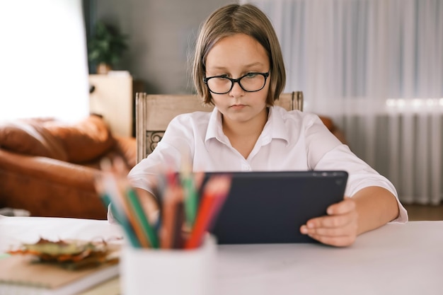 Uczennica Zaangażowana W Edukację Domową Oglądając Wykład Online Na Laptopie W Domu Dziecko Uczęszczające Do Zdalnej Wirtualnej Klasy Szkolnej Słuchającej Nauczyciela Zdalne Uczenie Się W Domu Za Pomocą Technologii