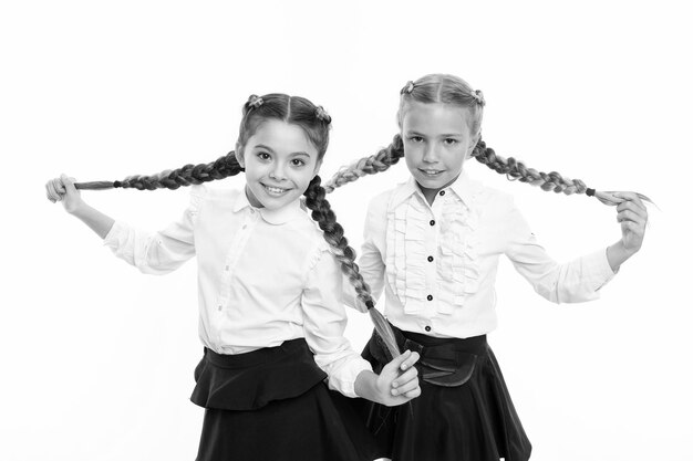 Uczennice noszą formalny mundurek szkolny Siostry dziewczynki z warkoczami gotowe do szkoły Koncepcja mody szkolnej Bądź jasny Szkolna przyjaźń Siostrzane relacje i bratnie dusze Na tej samej fali