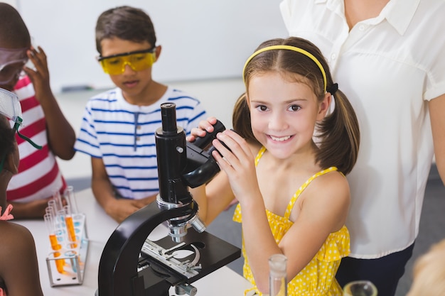 Uczennicy mienia mikroskop w laboratorium