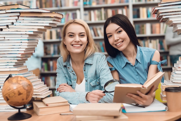 Uczniowie Czytają Książkę W Szkolnej Bibliotece.