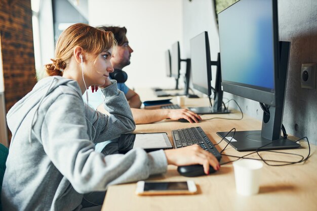 Zdjęcie uczniowie uczący się w klasie komputerowej młody człowiek przygotowujący się do testu na komputerze z powrotem do szkoły