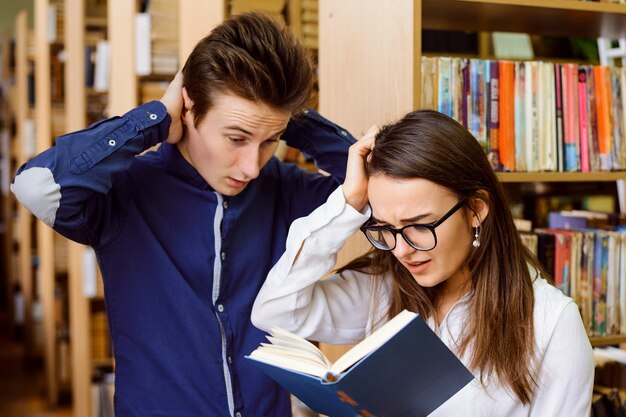 Uczniowie w bibliotece sprawdzają odpowiedzi w książce po egzaminie
