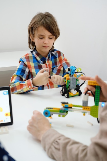 Uczniowie w szkolnej klasie programowania komputerowego budują i uczą się programowania robotów pojazdów wielofunkcyjnych