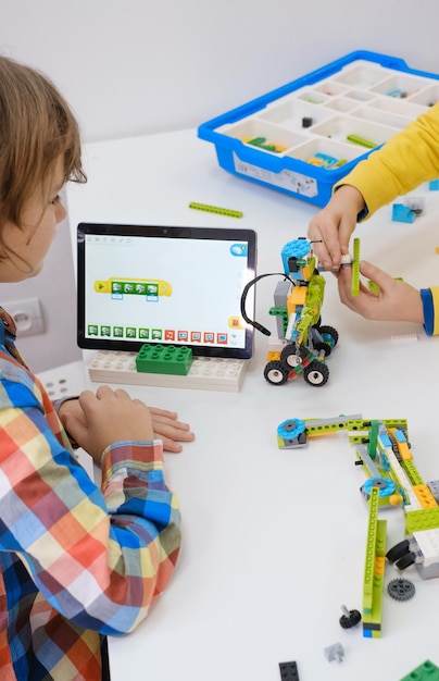 Uczniowie w szkolnej klasie programowania komputerowego budują i uczą się programowania robotów pojazdów wielofunkcyjnych