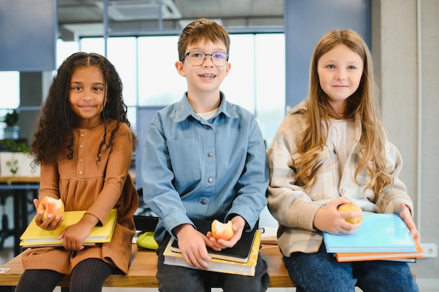 Zdjęcie uczniowie z różnych ras jedzą obiad przy biurku podczas przerwy w szkole
