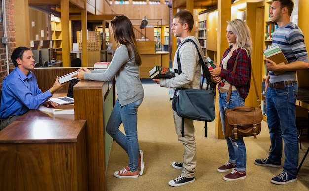 Uczniowie z rzędu przy kasie biblioteki